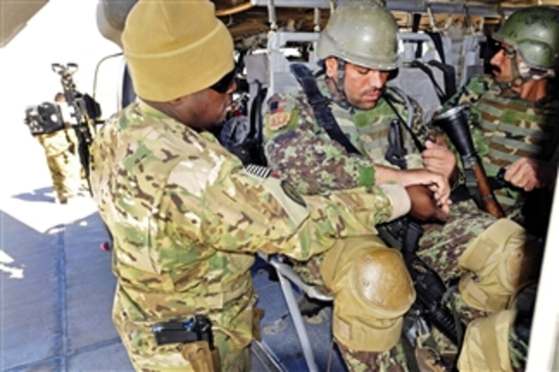 U.S. Army Chief Warrant Officer 2 Kenley Kirkland (left) assists Afghan soldiers in buckling in on a UH-60 Black Hawk helicopter during static load training for an air assault mission led by an Afghan air unit in Afghanistan's Kandahar province on Feb. 29, 2012.  Kirkland is a UH-60 pilot assigned to Company A, 2nd Battalion, 25th Aviation Regiment, 25th Combat Aviation Brigade.  