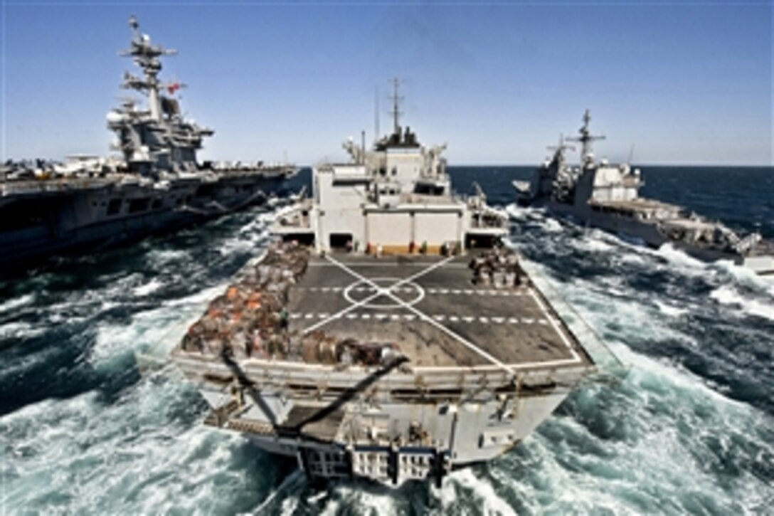 The fast combat support ship USNS Bridge prepares for a replenishment-at-sea mission with the aircraft carrier USS Carl Vinson, left, and the guided missile cruiser USS Bunker Hill, right, while under way in the Persian Gulf, March 6, 2012. The Carl Vinson and Carrier Air Wing 17 are deployed to the U.S. 5th Fleet area of responsibility.