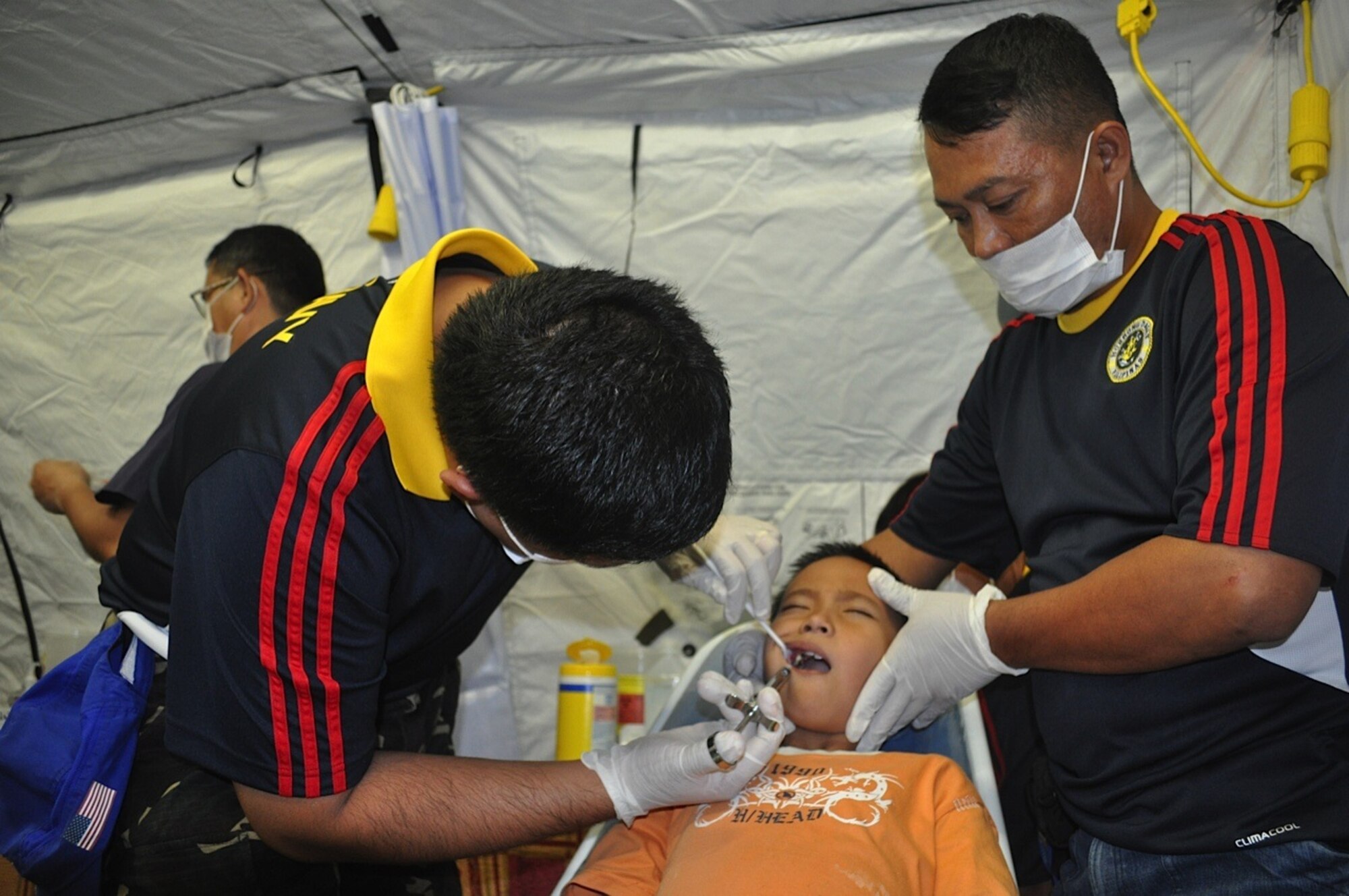 Six-year old, Arlie John Cimanes, grimaces as he gets a shot from Philippine Navy Maj. Ryan Glaraga, Philippine Navy Forces dentist from Southern Luzon, Philippines, March 8, 2012. Arlie is one of the lucky ones to have an appointment for medical care during Operation Pacific Angel-Philippines. There were hundreds of walk ins for the joint and combined humanitarian operation in Legazpi, City, Philippines. The operation began March 5 and runs through March 10. (U.S. Air Force photo/Master Sgt. Allison Day) 