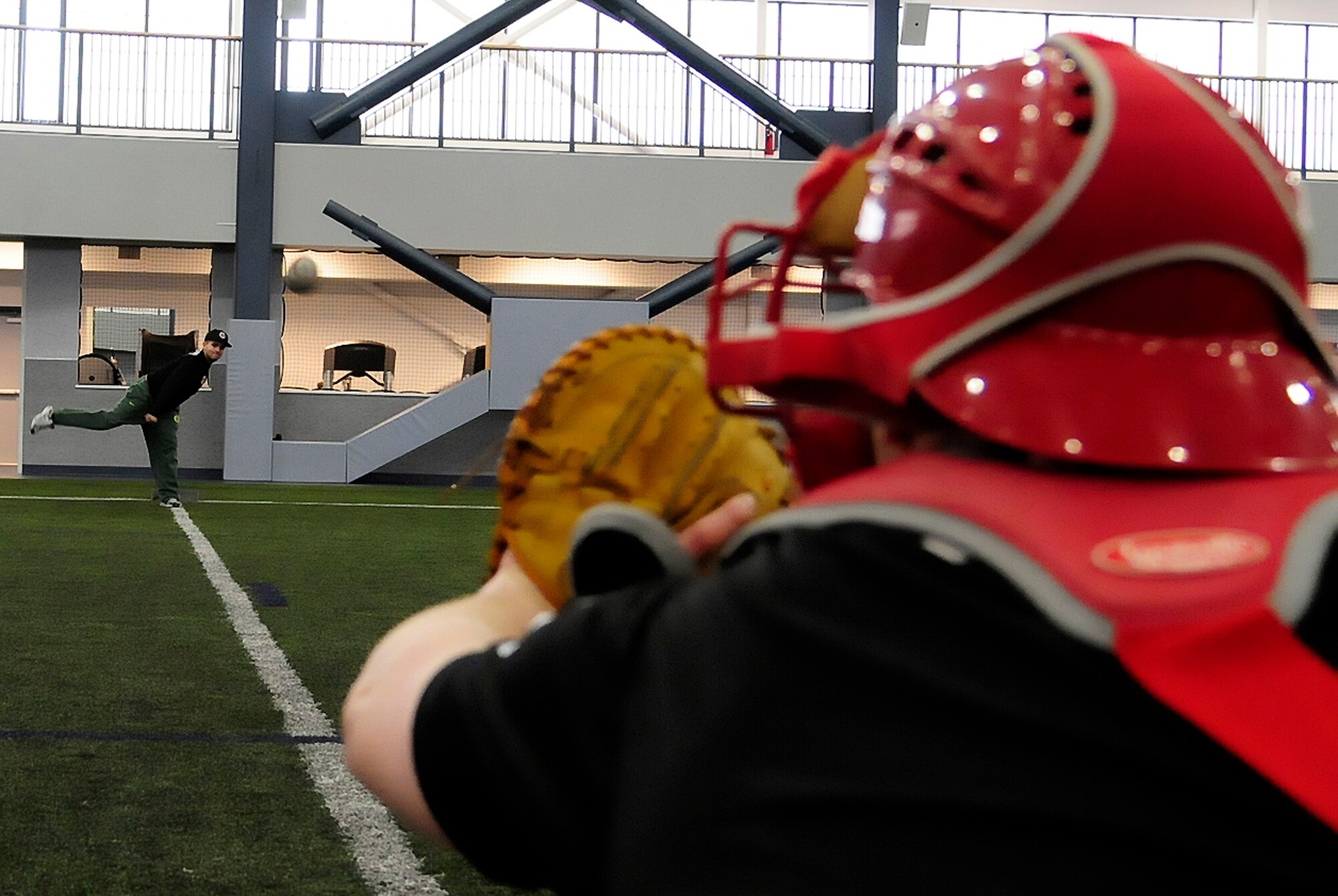 Airman Joseph Campolattaro, knowledge operations manager with the 354th Communications Squadron, and Staff Sgt. Jeffery Jones, aircraft maintenance scheduler with the 354th Maintenance Squadron, of the Eielson baseball team hone their pitching and catching skills during a practice session at Baker Field House March 3, 2012, Eielson Air Force Base, Alaska. Practices are held every weekend in the off-season to help team members stay in shape and game-ready. (U.S. Air Force photo/Airman 1st Class Zachary Perras)