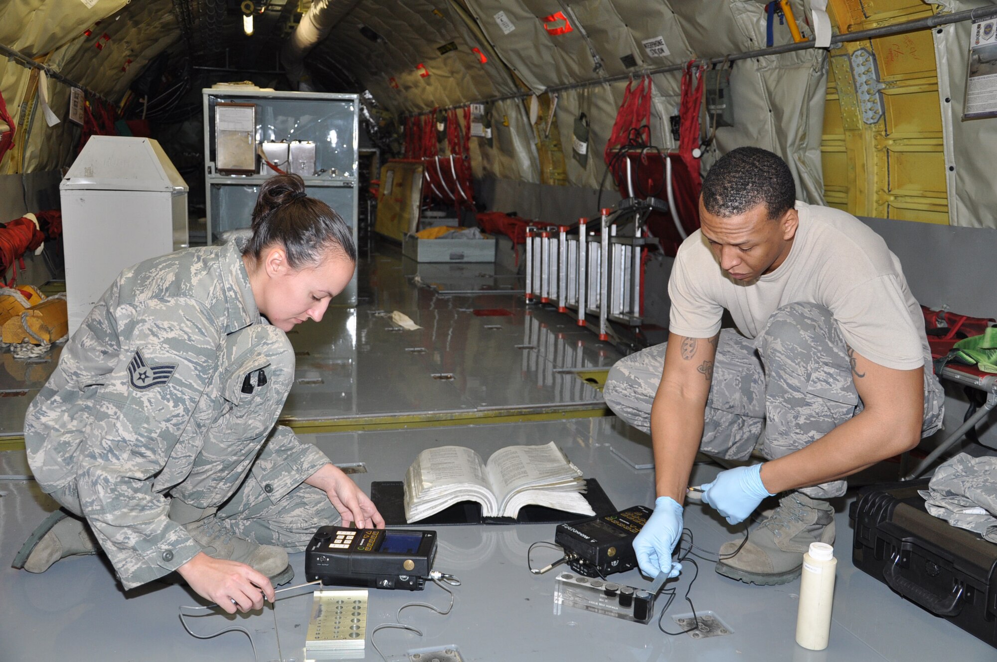 Staff Sgt. Amanda Mitchell, 931st Maintenance Squadron, calibrates an eddy current probe prior to inspecting a KC-135 Stratotanker's bulkhead for cracks while Staff Sgt. Bryan Tyler, 22nd Maintenance Squadron, calibrates an ultrasonic transducer prior to testing for subsurface defects. (Air Force photo by Tech. Sgt. Brannen Parrish)