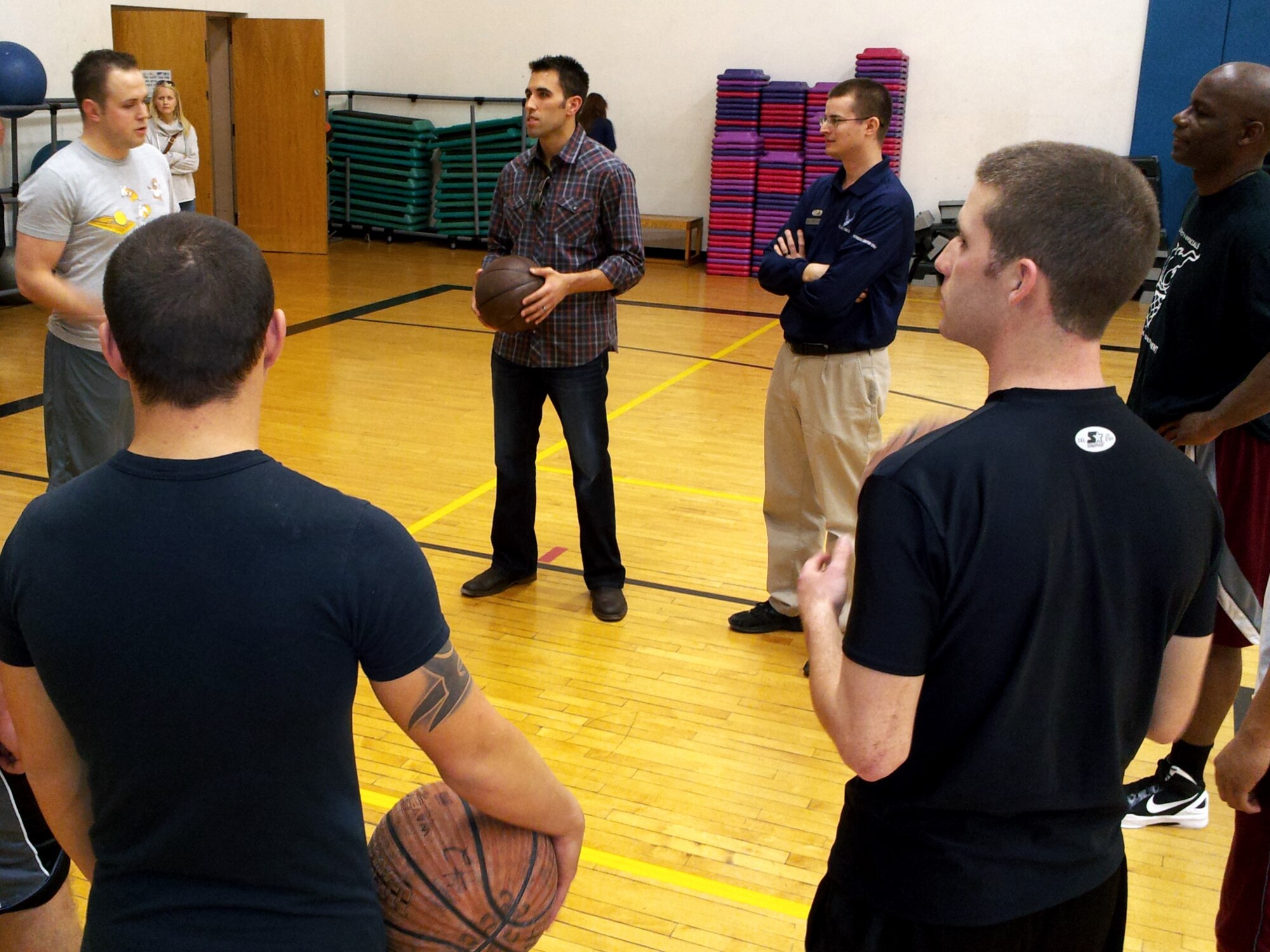 Aric Almirola, driver of the Air Force-sponsored No. 43 car, speaks with Airmen on the basketball court of the Nellis Air Force Base Fitness Center March 8, 2012. Almirola is scheduled to compete in the Kobalt Tools 400 NASCAR race at Las Vegas Motor Speedway March 11.