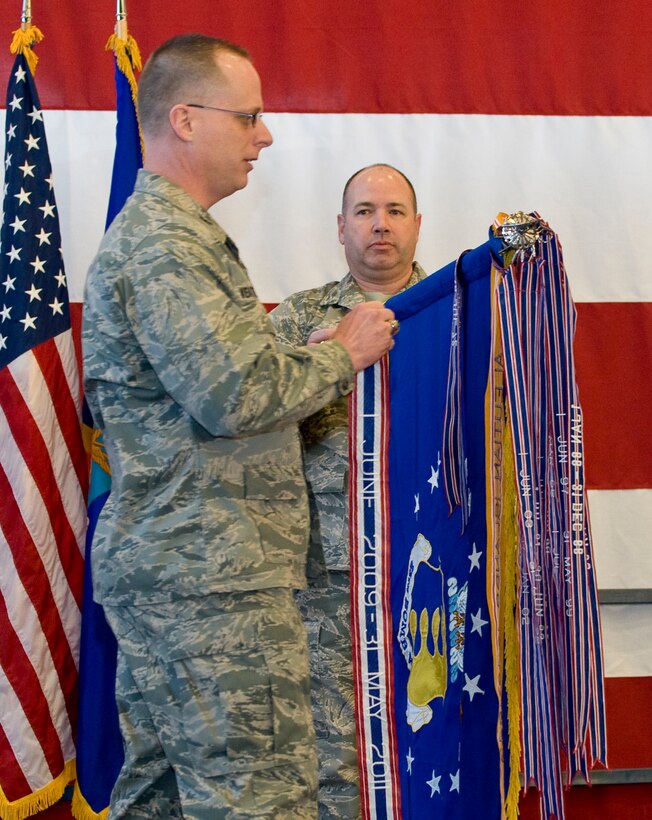 Col. Mark Weatherington, 28th Bomb Wing commander, attaches a Meritorious Unit Award streamer to the 28th BW guidon held by Chief Master Sgt. Brian Lavoie, 28th BW command chief, during a commander’s call in the Pride Hangar at Ellsworth Air Force Base, S.D., March 8, 2012. The 28th BW was awarded the MUA in recognition of the wing’s accomplishments between June 9, 2009 and May 31, 2011. (U.S. Air Force photo by Staff Sgt. Marc I. Lane/Released)