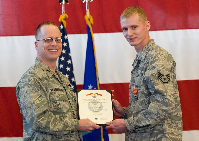 Col. Mark Weatherington, 28th Bomb Wing commander, pins the Air Force Combat Action Medal on Staff Sgt. Christopher Wiedmer, 28th Logistics Readiness Squadron vehicle operator, during a commander’s call in the Pride Hangar at Ellsworth Air Force Base, S.D., March 8, 2012. Wiedmer received the AFCAM for his actions during Operation New Dawn while assigned to the 387th Expeditionary Logistics Readiness Squadron, Joint Logistics Task Force 6, Camp Arifjan Kuwait as a navigation vehicle commander. (U.S. Air Force photo by Staff Sgt. Marc I. Lane/Released)