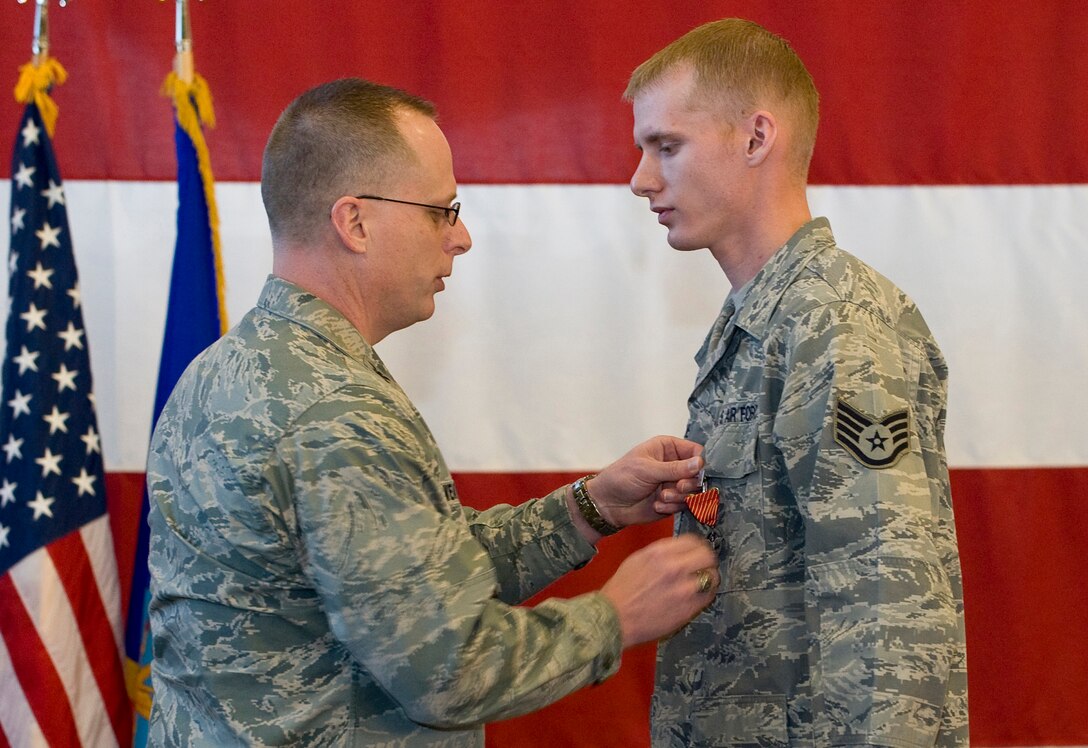 Col. Mark Weatherington, 28th Bomb Wing commander, pins the Air Force Combat Action Medal on Staff Sgt. Christopher Wiedmer, 28th Logistics Readiness Squadron vehicle operator, during a commander’s call in the Pride Hangar at Ellsworth Air Force Base, S.D., March 8, 2012. Wiedmer received the AFCAM for his actions during Operation New Dawn while assigned to the 387th Expeditionary Logistics Readiness Squadron, Joint Logistics Task Force 6, Camp Arifjan Kuwait as a navigation vehicle commander. (U.S. Air Force photo by Staff Sgt. Marc I. Lane/Released)