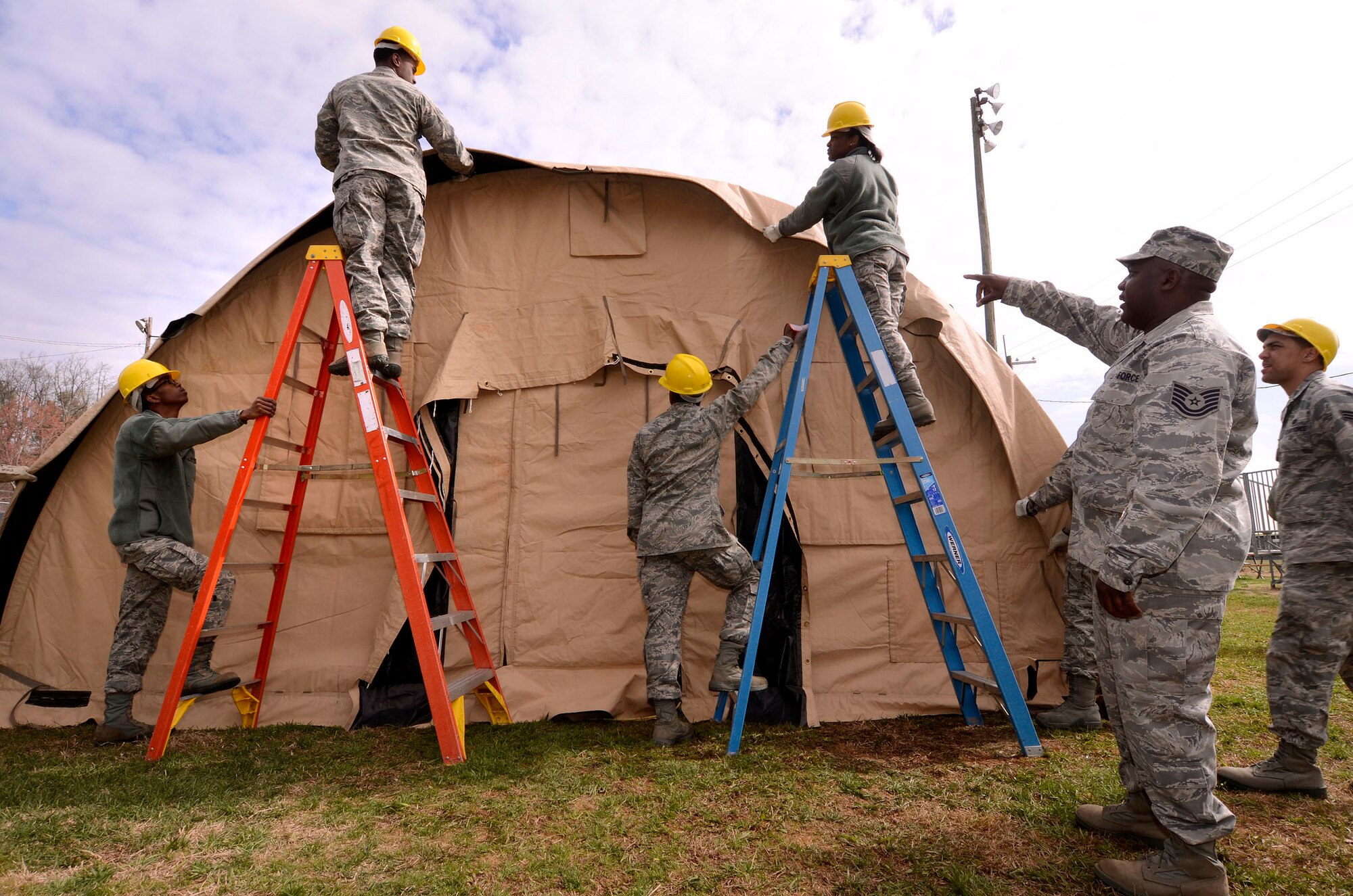 Tech. Sgt. Michael Todd, 94th Force Support Squadron readiness manager, directs fellow squadron Airmen on how to close up the end canvas panels of the Alaska personnel shelter at Dobbins Air Reserve Base, Ga, Mar. 7. Reservist with the 94th FSS performed and received annual tour training throughout the week in order to stay proficient or upgrade their specialized Air Force skills. (U.S. Air Force photo/ Brad Fallin)