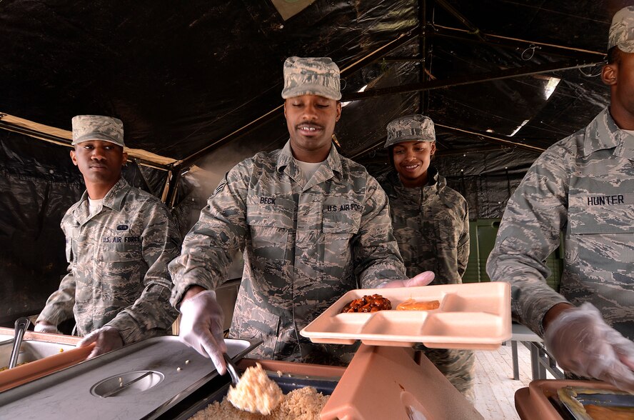 Airman 1st Class Darius Graham and Senior Airman Kenneth Beck serve food while Senior Airman Kisha Gilliam stands ready to restock the hot food trays in the 94th Force Support Squadron’s Single Pallet Expeditionary Kitchen (SPEK) at Dobbins Air Reserve Base, Ga., Mar. 7. Reservist with the 94th FSS performed and received annual tour training throughout the week in order to stay proficient or upgrade their specialized Air Force skills. (U.S. Air Force photo/ Brad Fallin)