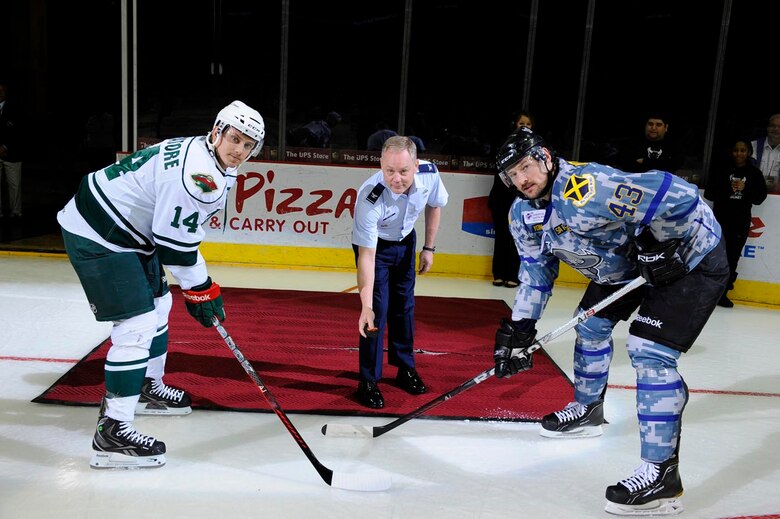 Col. Glenn E. Palmer, 737th Training Group commander, prepares to drop the puck as San Antonio Rampage defenseman Nolan Yonkman and Houston Aeros right wing Jon DiSalvatore prepare to face off. The simulated face off occurred prior to Saturday’s game at the AT&T Center. (Courtesy photo/Darren Abate, SA Rampage Media)
