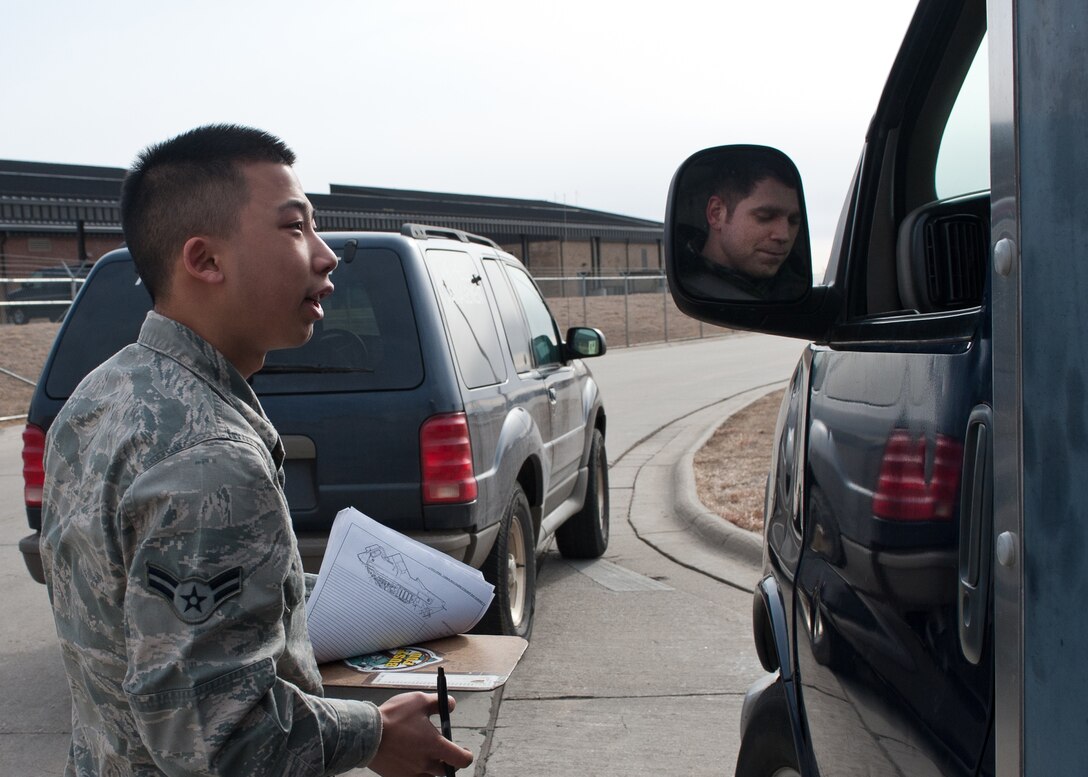Airman 1st Class Jonathan Yang, 28th Operations Support Squadron airfield management technician, asks Airman 1st Class Daniel Scott, 28th Aircraft Maintenance Squadron instrument flight controls journeyman, to provide his flightling driving credentials during a spot check at Ellsworth Air Force Base, S.D., March 7, 2012. A spot check allows airfield management Airmen to verify personnel are qualified to drive on the flightline. (U.S. Air Force photo by Airman Alystria Maurer/Released)