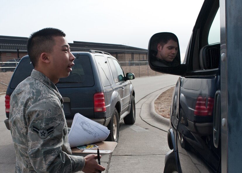 Airman 1st Class Jonathan Yang, 28th Operations Support Squadron airfield management technician, asks Airman 1st Class Daniel Scott, 28th Aircraft Maintenance Squadron instrument flight controls journeyman, to provide his flightling driving credentials during a spot check at Ellsworth Air Force Base, S.D., March 7, 2012. A spot check allows airfield management Airmen to verify personnel are qualified to drive on the flightline. (U.S. Air Force photo by Airman Alystria Maurer/Released)