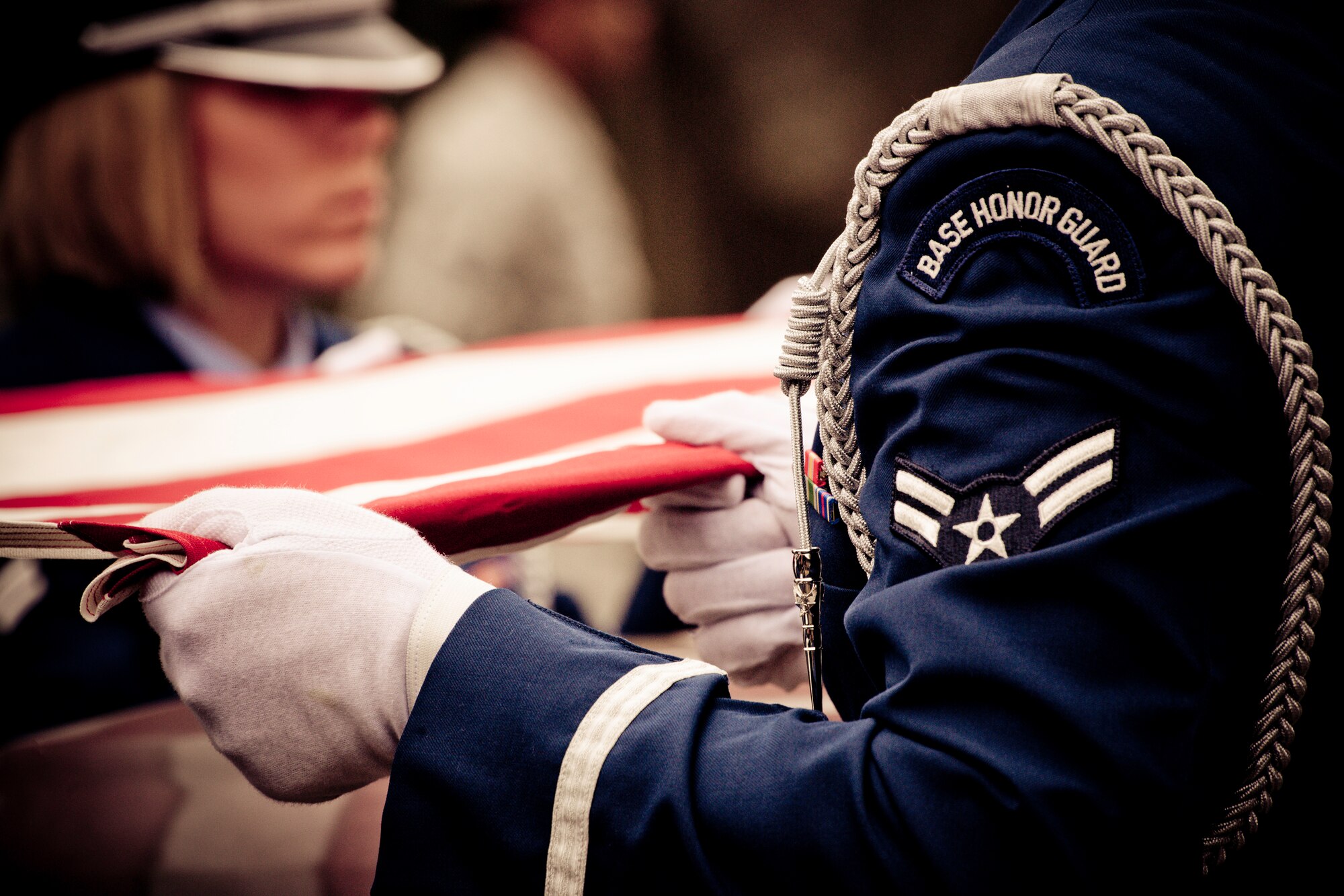 Airman 1st Class Wayne Phillips and five other members of the Eglin Honor Guard hold the flag tight above the casket during a mock funeral as part of the honor guard graduation. Approximately 16 new Airmen graduated from the 80-plus-hour course.  Prior to the graduation, the Airmen perform a full honors, military funeral to include flag detail, the 21-gun salute, pall bearers and bugler for friends, family and unit commanders.  (U.S. Air Force photo/Samuel King Jr.)