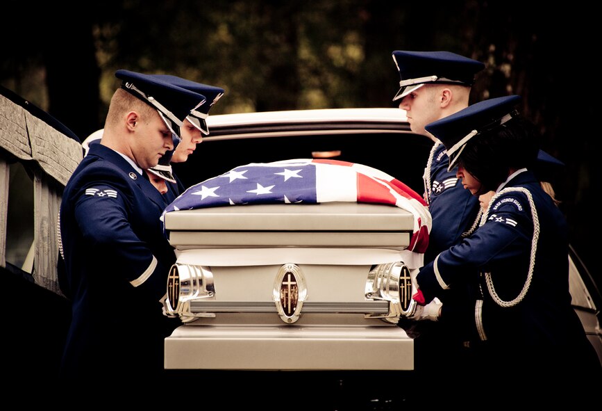 Members of the Eglin Honor Guard remove the flag-draped casket from the hearse during a mock funeral as part of the honor guard graduation. Approximately 16 new Airmen graduated from the 80-plus-hour course.  Prior to the graduation, the Airmen perform a full honors, military funeral to include flag detail, the 21-gun salute, pall bearers and bugler for friends, family and unit commanders.  (U.S. Air Force photo/Samuel King Jr.)