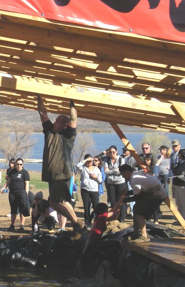 (Left) Maj. Andrew Hosler, Detachment 1, 53rd Computer Support Squadron commander, angles his way across greased monkey bars and a pool of freezing water in the Tough Mudder challenge, held Feb. 25 in southern California. (courtesy photo)