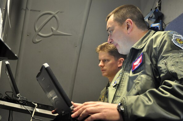 Capts. Thomas Kubler, left, 8th Airlift Squadron, and Josh Long, 62nd Operations Support Squadron, discuss the Joint Precision Airdrop System, or JPADS, before the first continental C-17 Globemaster III JPADS airdrop March 8, 2012, at Joint Base Lewis-McChord, Wash. JPADS is an airdrop system that uses Global Positioning Satellite, steerable parachutes and an onboard computer to steer loads to a designated point of impact on a drop zone. (U.S. Air Force photo/Airman 1st Class Leah Young)