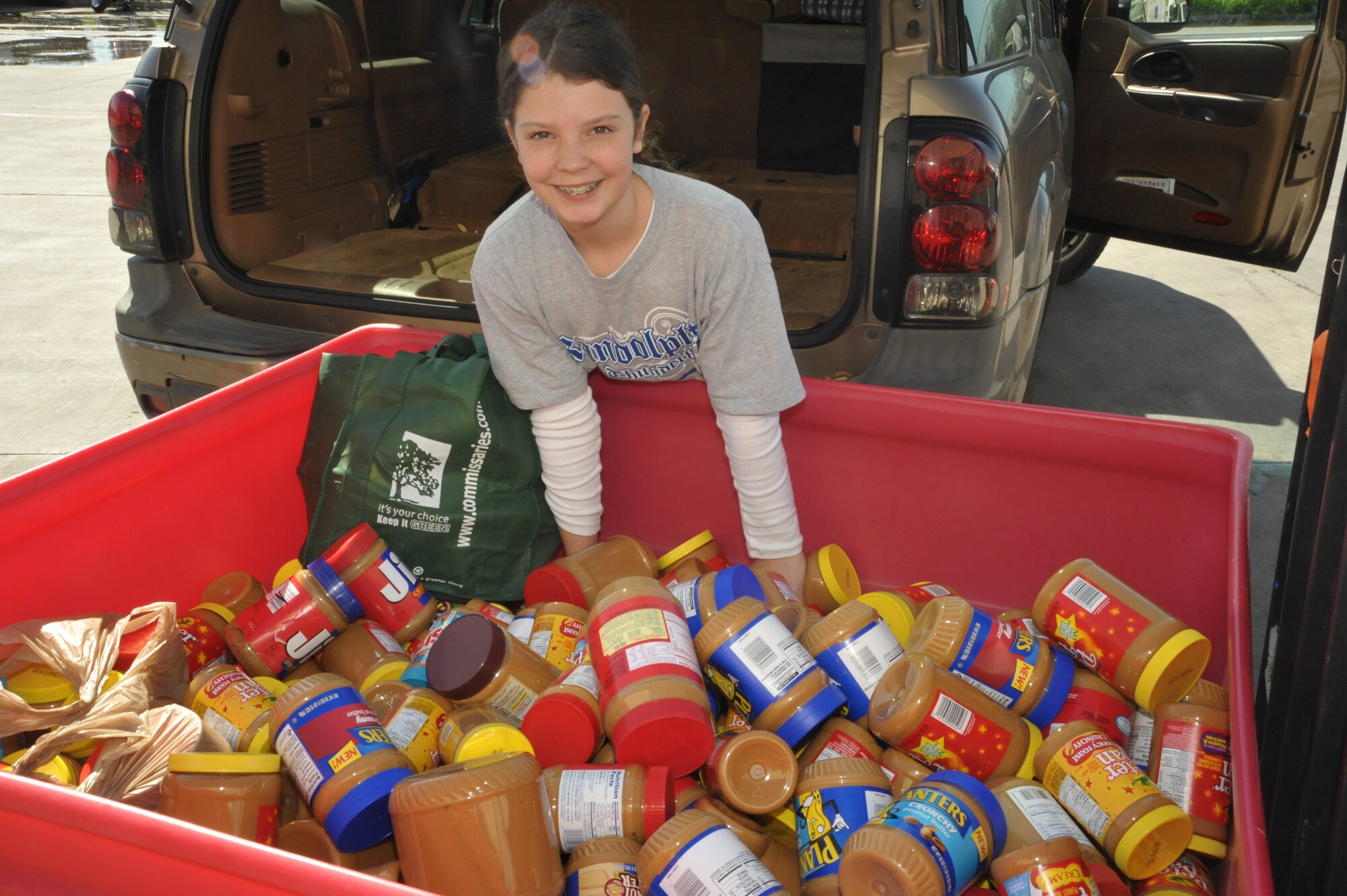 Randolph Elementary School student Emma Driggers delivers more than 500 jars of peanut butter to the San Antonio Food Bank March 5. (US Air Force photo by Airman 1st Class Alexis Siekert)