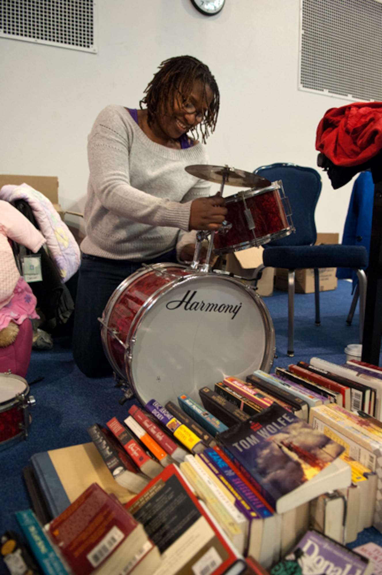 Staff Sgt. Michele Gaines, 90th Force Support Squadron, assembles a drum kit which will be put up for sale, along with books and other items, in her booth in the Fall Hall Community Center March 3. (U.S. Air Force photo by R.J. Oriez)