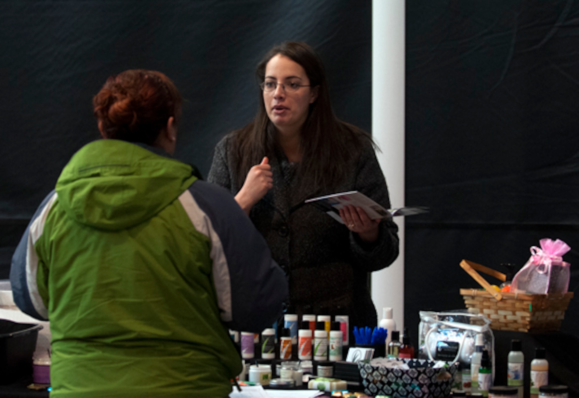Jaela Cicarelli talks to Anna Gonzalez about skincare products at her booth in the flea market held in Fall Hall Community Center March 3. Cicarelli was just one of more than 50 venders who purchased booths for the event. (U.S. Air Force photo by R.J. Oriez)