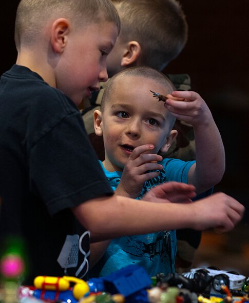 Kaleb Cain and Ryan Lambert, left, both 7, play with toys at a booth in the flea market in Fall Hall Community Center March 3 at a booth run by Ryan’s father, Master Sgt. Kevin Lambert, 20th Air Force. (U.S. Air Force photo by R.J. Oriez)