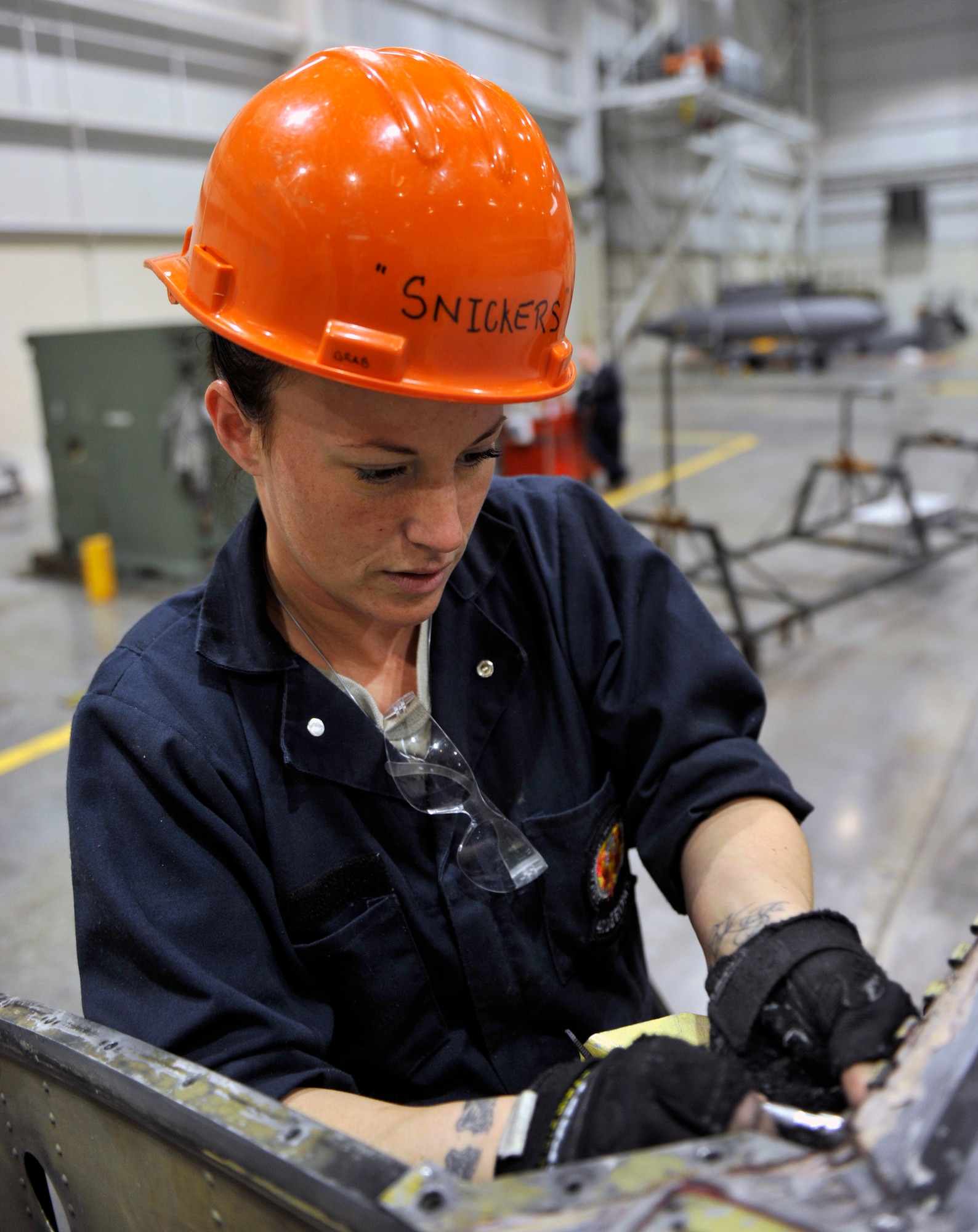 Tech. Sgt. Jessica Fordham, a 402nd Expeditionary Depot Maintenance depot structural craftsman at Robins Air Force Base, Ga., removes hi-locs from a C-130 wing, March 8, 2012, at Little Rock Air Force Base, Ark. Fordham and other members of the 402nd EDMX will spend approximately 58,000 hours restoring one of the C-130’s that was damaged from an enhanced Fujita 2 tornado that struck the base. (U.S. Air Force photo by Airman 1st Class Rusty Frank)