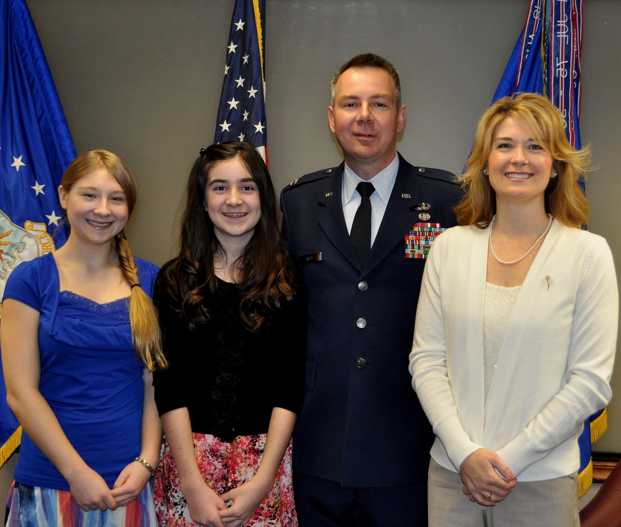 TRAVIS AIR FORCE BASE, Calif. -- Col. Carl L. Reed II is all smiles after his promotion ceremony Mar. 1, 2012. Family and friends at the Reserve's 349th Air Mobility Wing celebrated with him as he pinned on his eagles. Pictured from the left: daughers Sarah and Olivia, Col. Reed, and his wife, Simone. (U.S. Air Force photo/Senior Master Sgt. Ellen L. Hatfield)