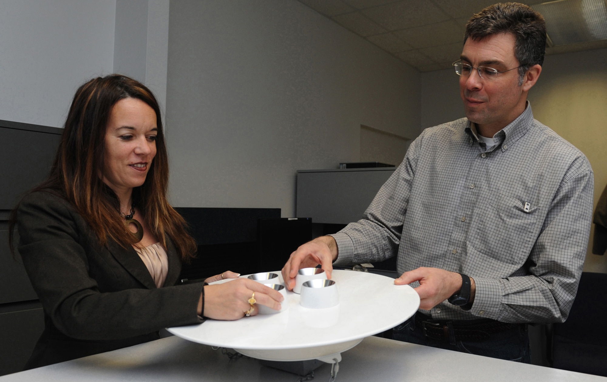 WHITEMAN AIR FORCE BASE, Mo. -- Andrea Goodson, 509th Civil Engineer Squadron  chief of asset optimization, and Jack Allen, 509th CES base energy manager, display a new LED high bay light that they are researching to be installed in a several high bays across the installation. The Air Force Global Strike Command base duo is responsible for assessing future and current energy projects, tracking energy consumption and recognizing solutions for projects to save energy. (U.S. Air Force photo/Airman 1st Class Bryan Crane) (RELEASED)