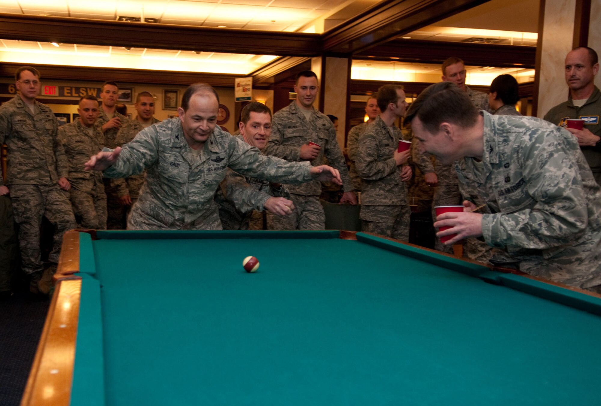 HANSCOM AIR FORCE BASE, Mass. – Col. Kevin Muckerheide and Col. Juan Gaud (middle) battle for ball position during Hanscom’s Crud Tournament at the Minuteman Commons March 2. Crud is a team game usually played by military members on a billiard’s or snooker table. In addition to the tournament, many members of the Hanscom community came out to take part in St. Patrick’s Day-themed First Friday activities. (U.S. Air Force photo by Walter Santos)