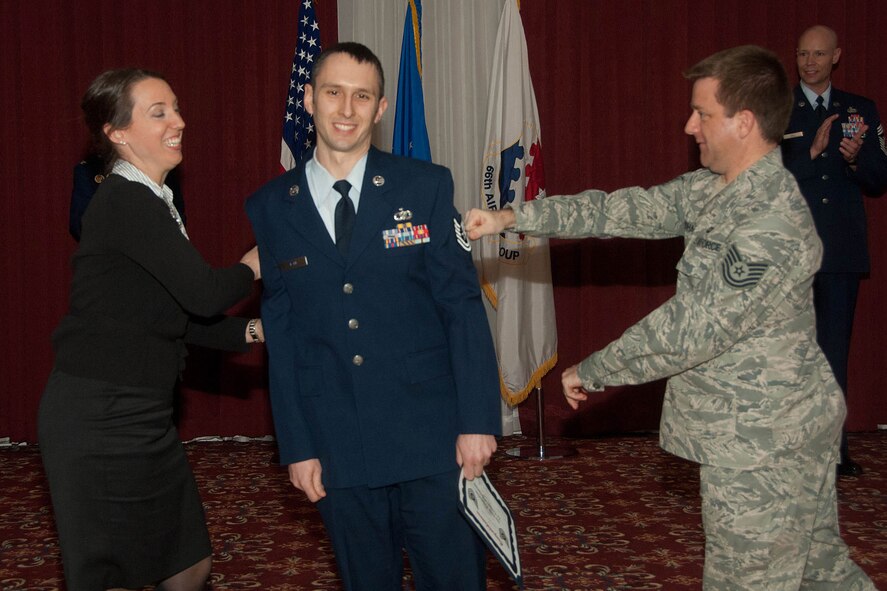 HANSCOM AIR FORCE BASE, Mass. - One of Hanscom’s newest technical sergeants, Christopher Stahl, from the Band of Liberty, gets his stripes tacked on by his wife and Tech. Sgt. Andrew Fordham during the March promotion ceremony at the Minuteman Commons Feb. 29. Nearly 20 enlisted members and officers from Hanscom and its geographically separated units will promote during the month of March. (U.S. Air Force photo by Linda LaBonte Britt)