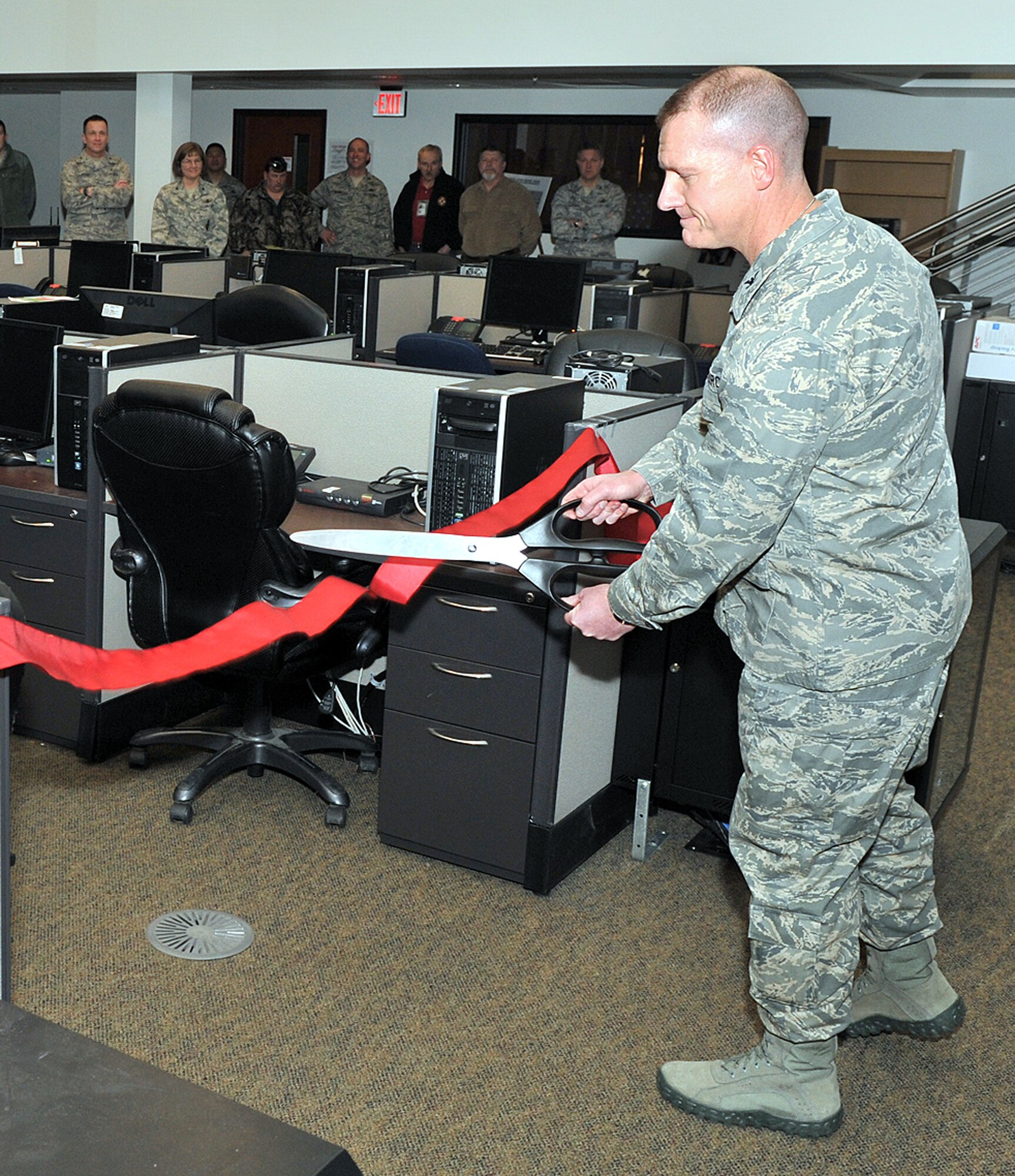 Col. Robert Stanley, 341st Missile Wing vice commander, cuts the ribbon to officially open Malmstrom's Installation Control Center while other members of Wing One look on. The new facility is the only one of its kind in Air Force Global Strike Command. (U.S. Air Force photo/John Turner)