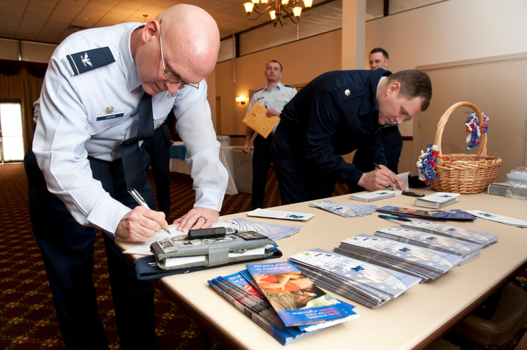 Col. Christopher Luedtke, 87th Mission Support Group commander and Lt. Col. Jeremy Novak, 87th Security Forces Squadron commander, contribute to the Air Force Assistance Fund Kick-Off March 5 at Tommy B's Community Activities Center. The goal is to collect $91,000 between March 5 and April 13 which will lend critical support to fellow Airmen and their families – active duty and retired. (U.S. Air Force photo by Russ Meseroll/Released)