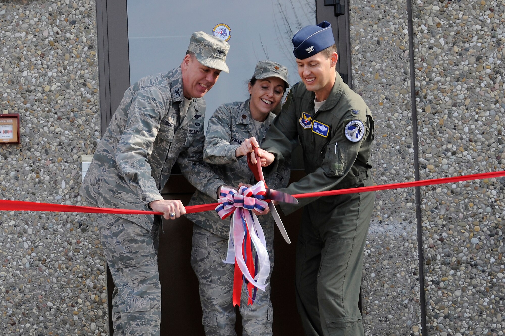 From left to right, Col. John Shapland, 435 Air Ground Operations Wing commander, Maj. Angela Freeman 1st Communications Maintenance Squadron commander, Col. Eric Cain, Air Force Standard Organization flight commander cut the ribbon prior to opening the Regionalized Maintenance Center on Kapaun Air Station, Germany, March 9. The RMC will streamline the maintenance of all Air Force air traffic control and landing systems around the globe, saving the Air Force an estimated $336 million by 2025.