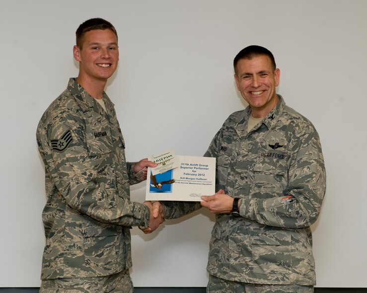 U.S. Air Force Col. Walter Ward, 317th Airlift Group commander, presents Staff Sgt. Morgan Huffman, 317th Aircraft Maintenance Squadron, with the 317th AG superior performer award, March 8, 2012, at Dyess Air Force Base, Texas. Every month each group selects a person or team who has shown superior performance to be recognized in front of wing leadership. (U.S. Air Force photo by Airman 1st Class Jonathan Stefanko/ Released)