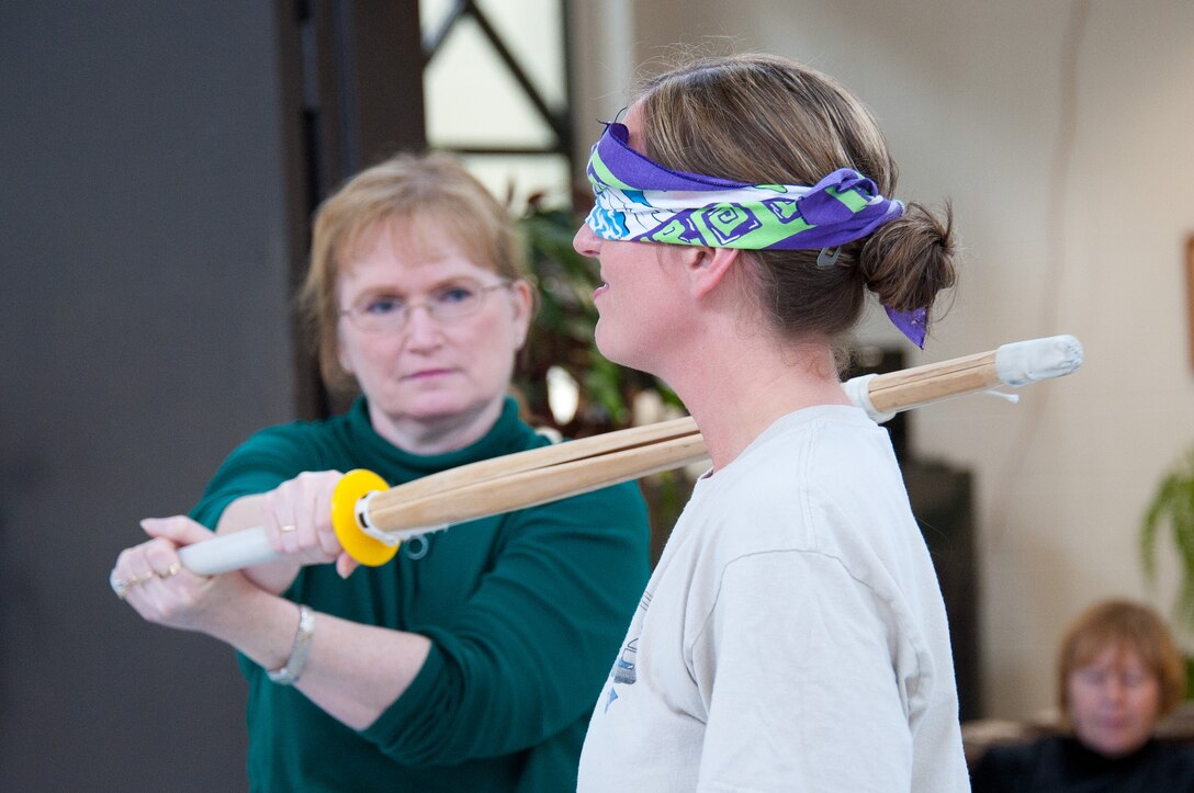 Following drills to teach avoidance techniques, Robison demonstrates on Tech. Sgt. Robin McWhirter of Air Force Legal Operations Agency that even when blindfolded, a person's body is aware of danger and will instinctively avoid it. Robison presented a self-defense class at the Gunter Community Center March 1, hosted by Maxwell-Gunter's Women's History Month committee. (Air Force photo/Melanie Rodgers Cox)