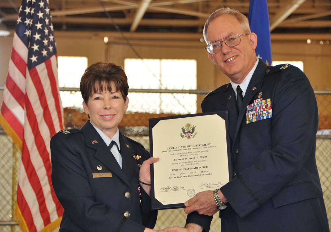 Col. Pamela Scott, 433rd Medical Squadron commander accepts a Certificate of Retirement from Col. William Blanchette, 433rd Medical Group commander during a ceremony at the Kelly Annex March 4, 2012.  She is retiring after 30 years of medical service in both Air Force active duty and the Reserve components. Scott encouraged Airmen to consider changes and hardships as opportunities to move forward in both their military career and personal lives during her retirement speech. (U.S. Air Force photo/Senior Airman Viola Hernandez)