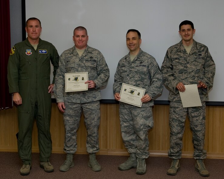 U.S. Air Force Col. Mark Bennett, 7th Operations Group commander, presents airmen from the 436th Training Squadron the February 7th OG superior performer award, March 8, 2012, at Dyess Air Force Base, Texas. Every month each group selects a person or team who has shown superior performance to be recognized in front of wing leadership. (U.S. Air Force photo by Airman 1st Class Jonathan Stefanko/ Released)
