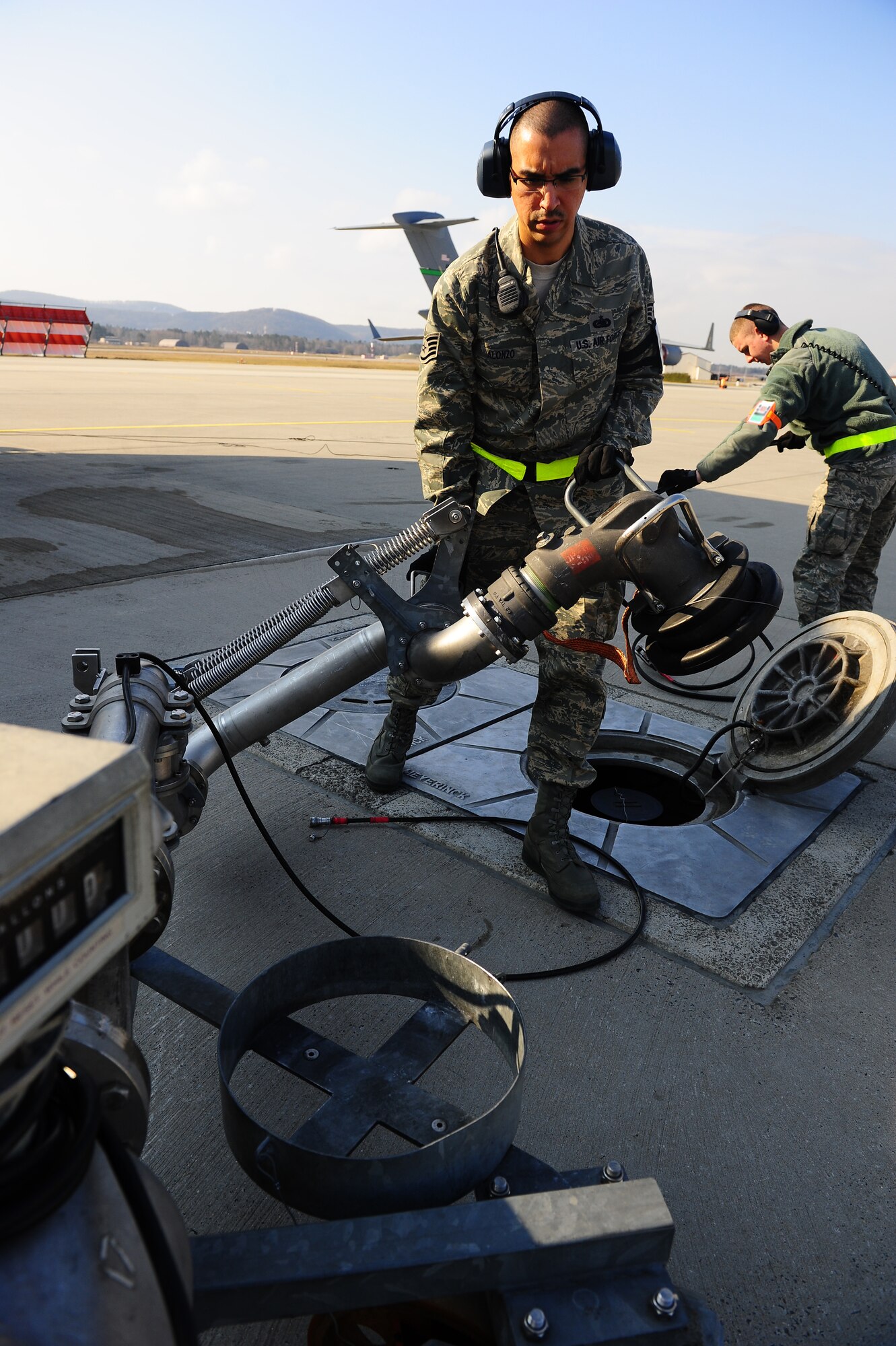 U.S. Air Force Staff Sgt. Jason Alonso and Airman 1st Class Ryan Lee, 86th Logistics Readiness Squadron fuels distribution mobile operators, reconfigure a fueling pantograph to remove it after refueling a C-17 Globemaster III, Ramstein Air Base, Germany, March 6, 2012. Airmen assigned to the fuels management flight issued more than 130 million gallons of fuel in fiscal year 2011.  (U.S.Air Force photo/Airman Brea Miller)