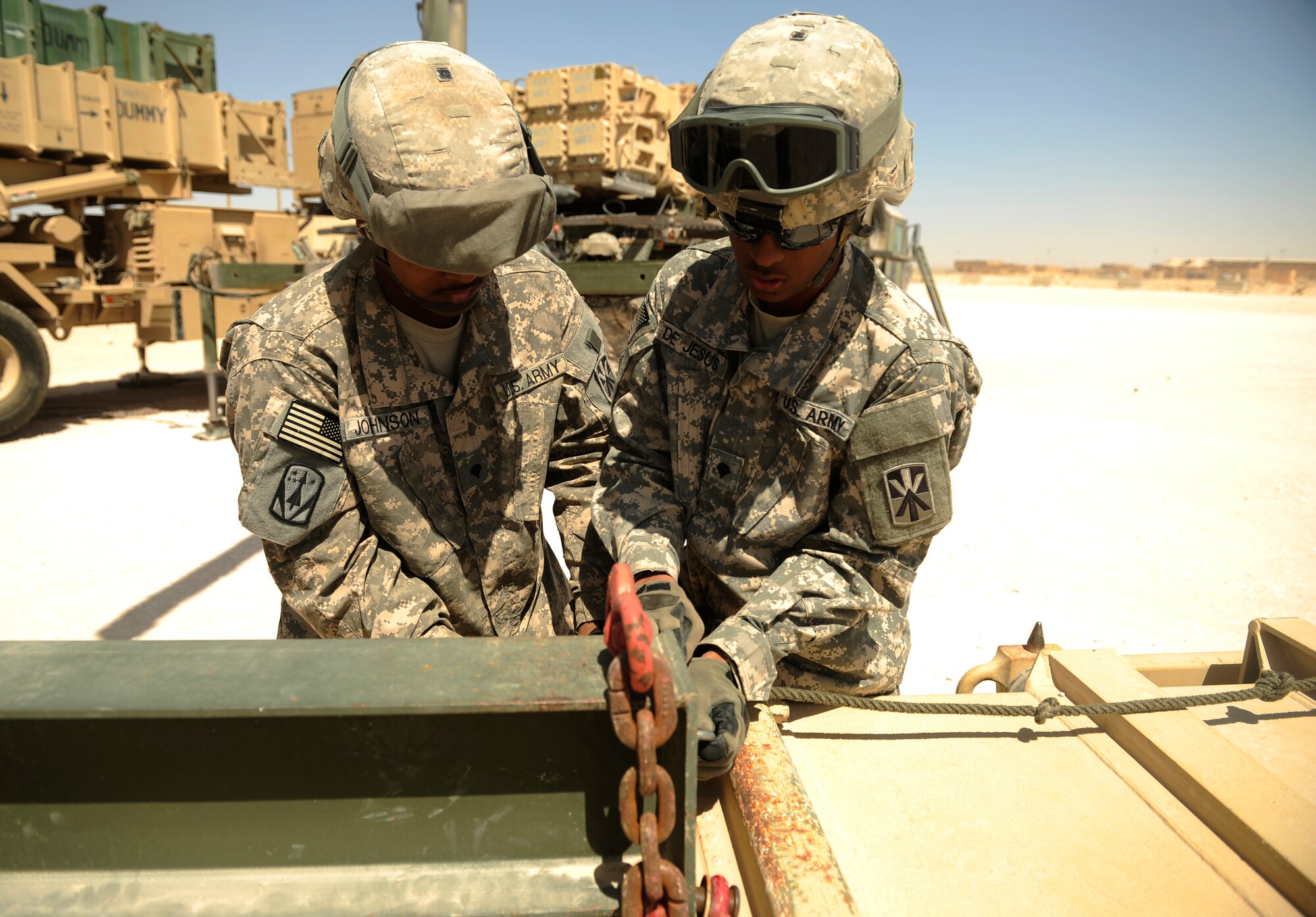 SOUTHWEST ASIA – U.S. Army Spc. Issac Johnson and Spc. Ernesto De Jesus, Bravo 5-52nd Air and Missile Defense Battery launcher station technicians, secure a launcher canister to a crane during a crew drill here March 6, 2012. The Soldiers train on a PAC-2 launcher, which protects the region against aerial attack, missile attacks, and unauthorized surveillance. (U.S. Air Force photo/Staff Sgt. Nathanael Callon)