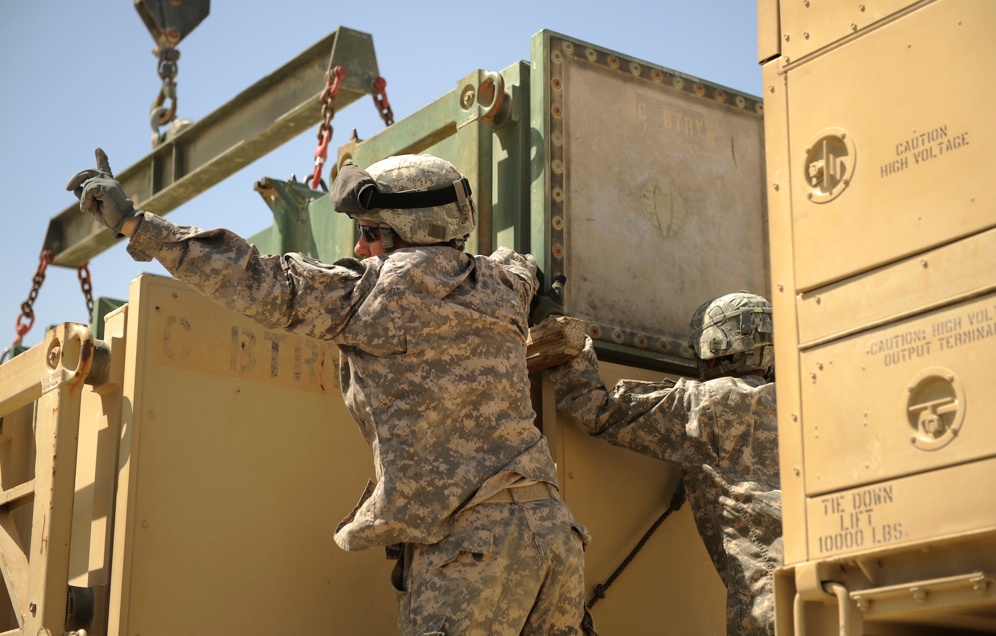 SOUTHWEST ASIA – U.S. Army Staff Sgt. Christopher Burnham, Bravo 5-52nd Air and Missile Defense Battery safety NCO and native of Houston, signals for a crane operator to raise a launcher canister during a crew drill here March 6, 2012. The five-man crew trains and works together on a daily basis to keep a strong continuity and be a more cohesive unit. Unlike many Air Force deployments, these Soldiers are stationed together at Fort Bliss, Texas, and deploy together as a part of the same team. (U.S. Air Force photo/Staff Sgt. Nathanael Callon)