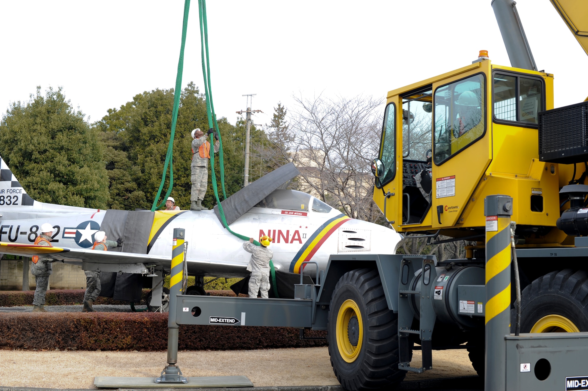 YOKOTA AIR BASE, Japan -- Airmen from the 374th Civil Engineering Squadron. place a 15,000 lb. synthetic sling around the F-86 F static display at Yokota Air Base, Japan, March 7, 2012. The plane, known as the Nina II, was moved from Nina Circle to its new location between Fifth Air Force and the new Japanese Air Self Defense Force Air Defense Operations Headquarters buildings. (U.S. Air Force photo/Staff Sgt. Stacy Moless)