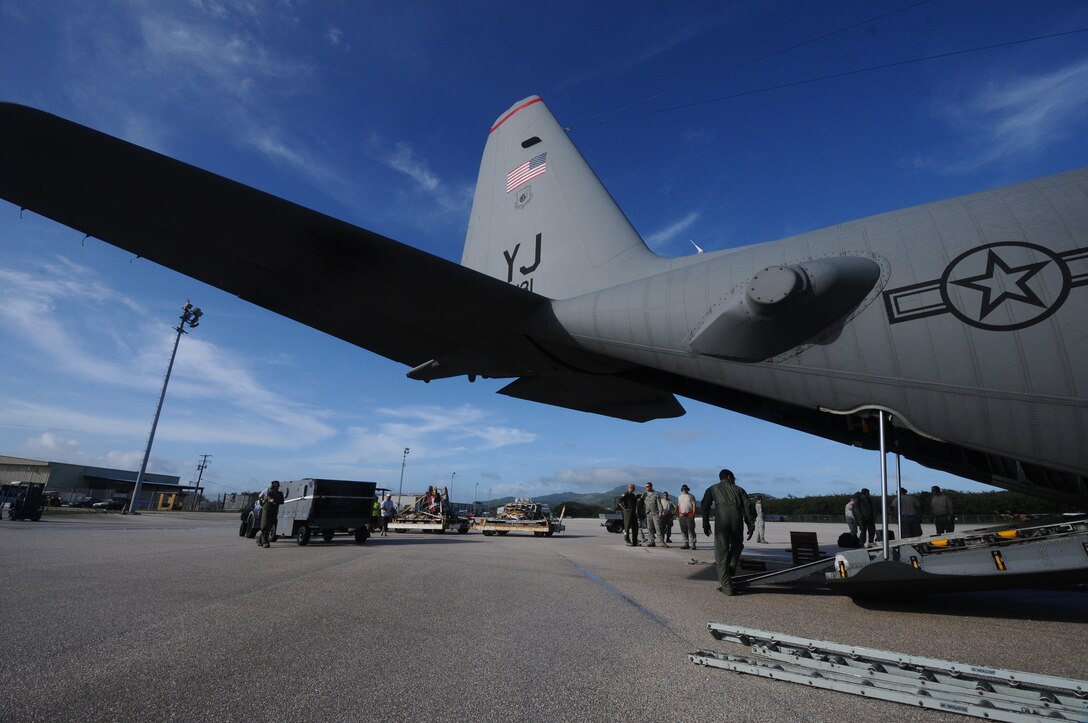 Crew Members of the 374th Airlift Wing off load maintenance equipment at Saipan International Airport from a C-130, in support of the F-16 Fighting Falcon from Eielson Air Force base, Alaska that made an emergency landing at Saipan, Feb. 23.(U.S. Air Force photo/Senior Airman Carlin Leslie)
