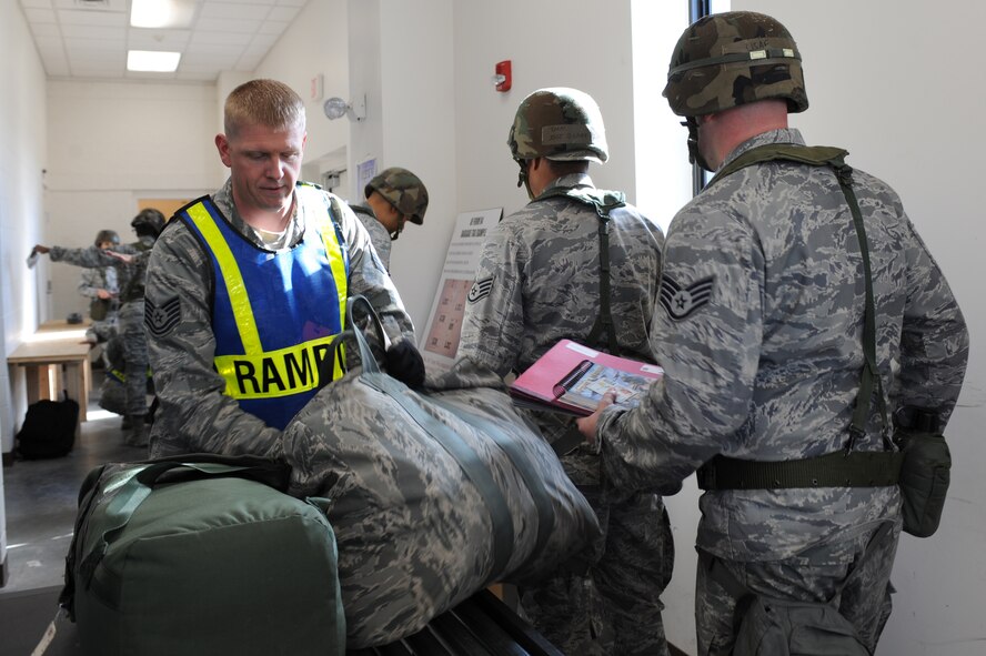 U.S. Air Force Tech. Sgt. Steven Whitmore, left, processes bags through an x-ray machine in the Personnel Deployment Facility on Seymour Johnson Air Force Base, N.C., Mar. 5, 2012. The bags are scanned to search for prohibited items such as knives, firearms, and explosives. Whitmore, 4th Communications Squadron NCO in charge of transmission systems, is from Starlight, Pa. (U.S. Air Force photo/Airman 1st Class John Nieves Camacho/Released)