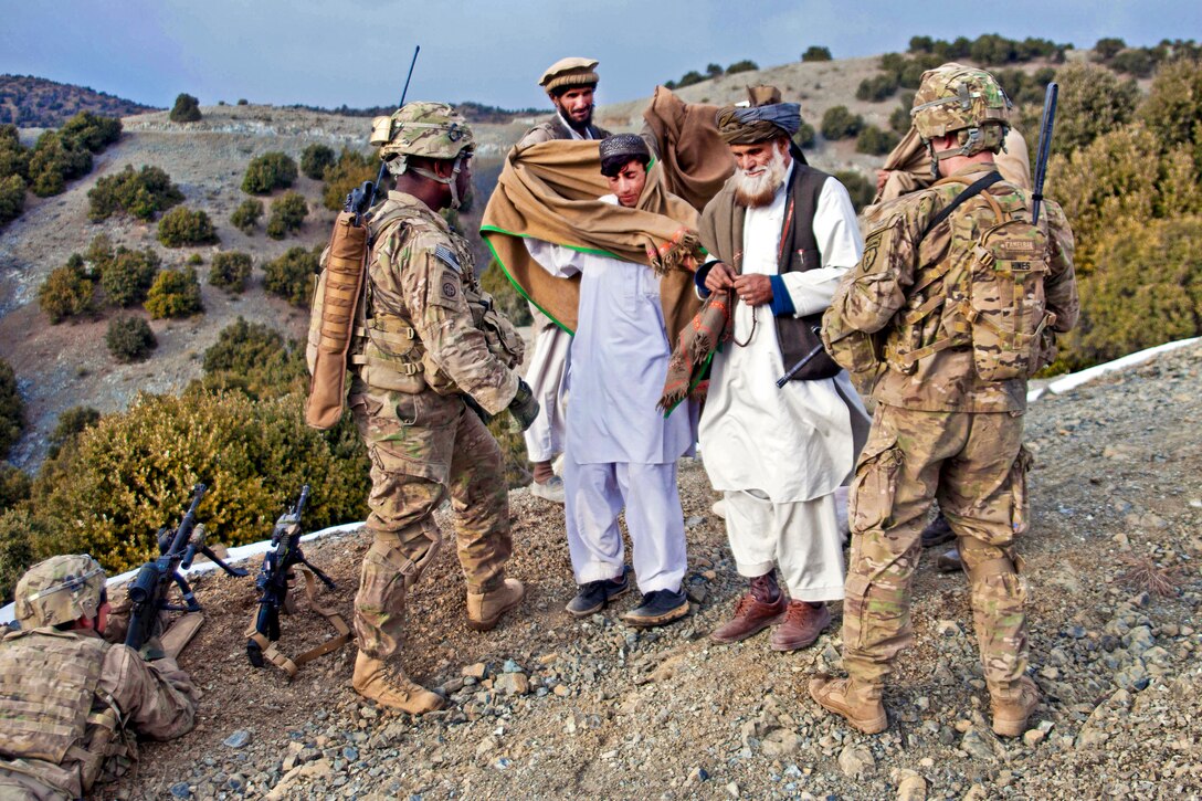 U.S. Army Staff Sgt. Omar Jackson, left, and U.S. Army 2nd Lt. Ross Hines greet Afghans while on a patrol near Enzarkay Pass in Afghanistan's Paktya province, March 2, 2012. Jackson and Hines are assigned to Company A, 3rd Battalion, 509th Infantry Regiment.