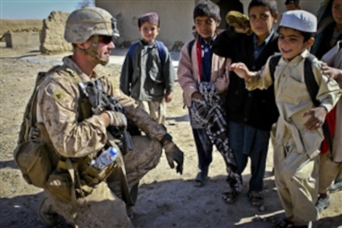U.S. Marine Corps Cpl. Joshua Brooks greets students at the school in Khan Neshin, Helmand province, Afghanistan, on Feb. 25, 2012.  Brooks is assigned to Team 3, Civil Affairs Detachment 11-2.  The Marines of Team 3 are providing guidance to the regional government and are helping them construct a new school.  