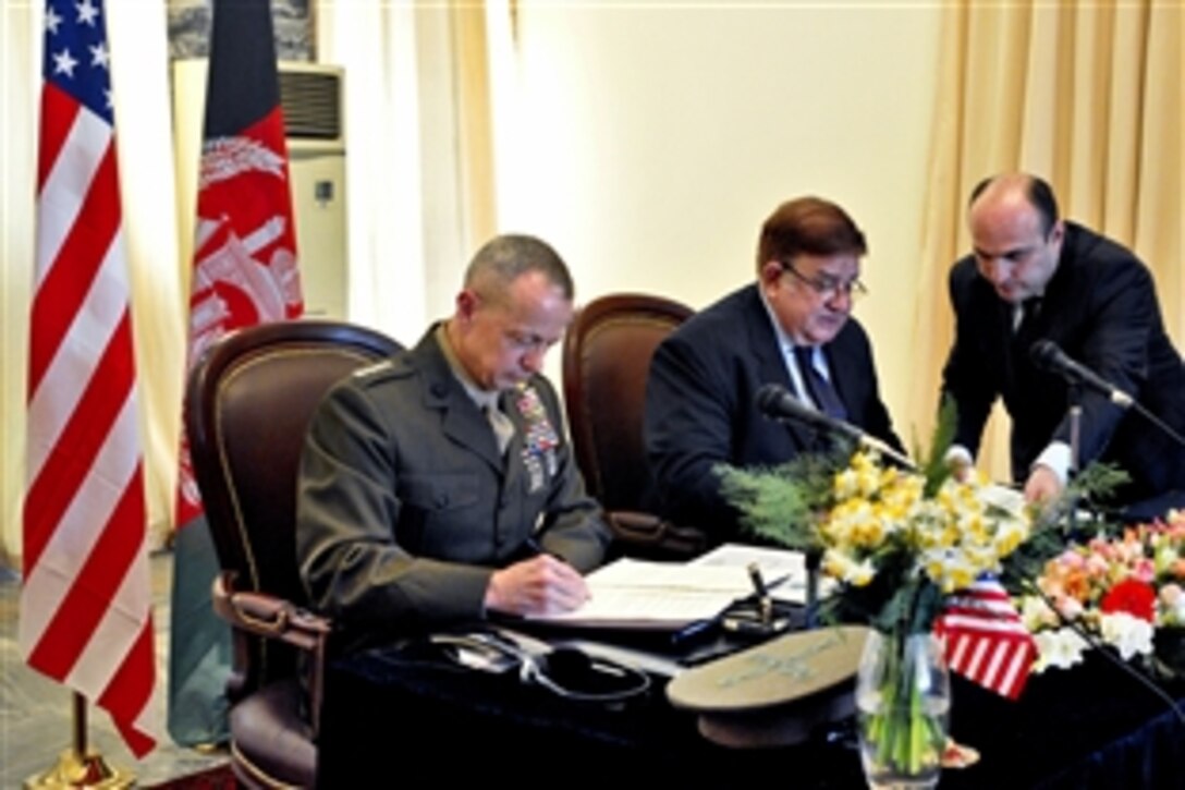 U.S. Marine Corps Gen. John R. Allen, commander of U.S. and international forces in Afghanistan, and Afghan Defense Minister Abdul Rahim Wardak sign an agreement in Kabul, Afghanistan, March 9, 2012, to turnover the detention facility in Parwan, Afghanistan, to Afghan control.