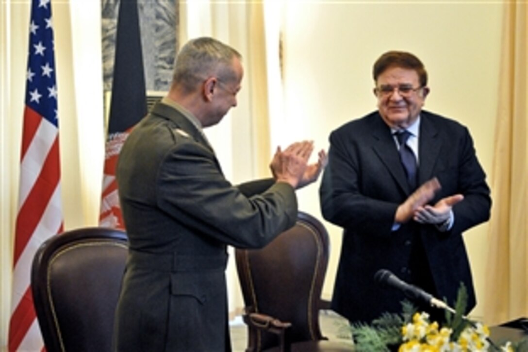 U.S. Marine Corps Gen. John R. Allen, commander of U.S. and international forces in Afghanistan, joins Afghan Defense Minister Abdul Rahim Wardak in applauding their countries’ collaborative efforts after signing an agreement to turnover the Parwan detention facility to Afghan control at the Afghan Ministry of Foreign Affairs in Kabul, Afghanistan, March 9, 2012.