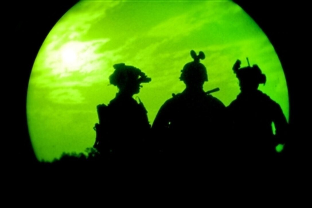 As seen through a night-vision device, Air Force special forces gather following a simulated attack during the Emerald Warrior exercise on Hurlburt Field Air Force Base, Ala., March 8, 2012. The primary purpose of Emerald Warrior is to exercise special operations components in urban and irregular warfare settings to support combatant commanders in theater campaigns.