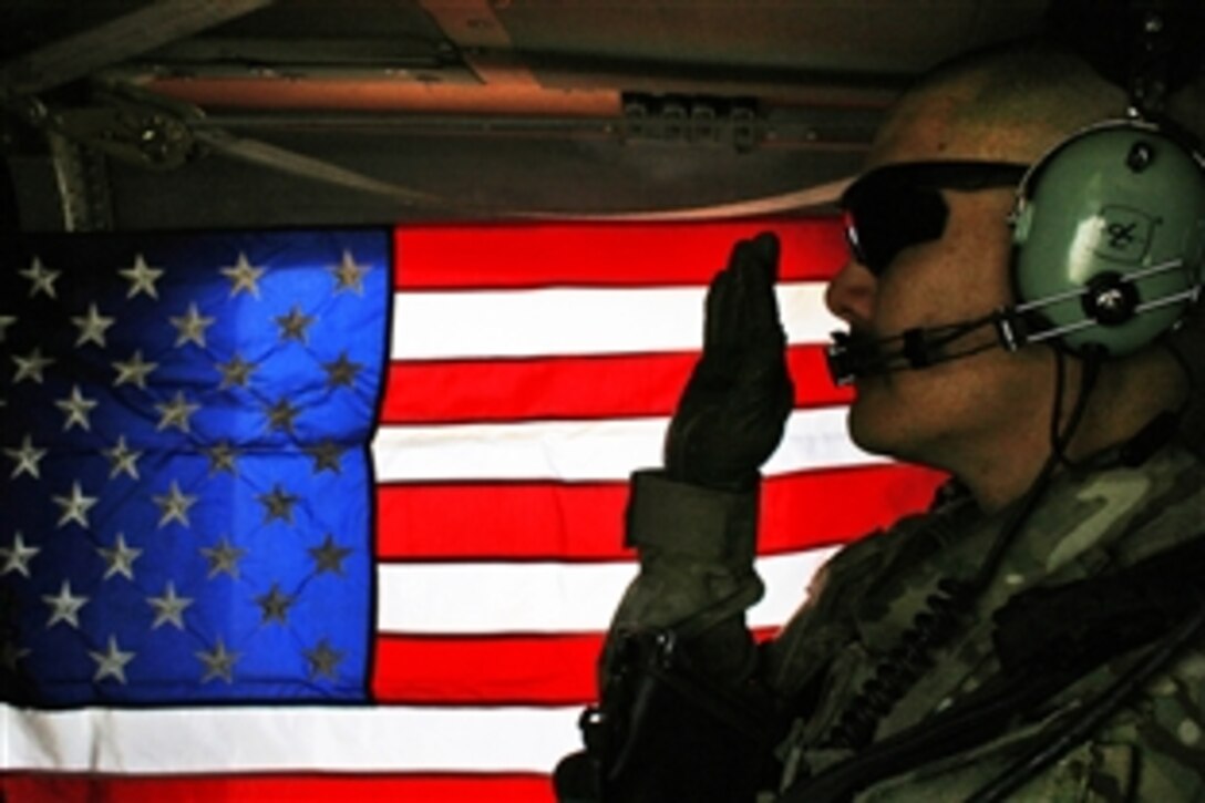 U.S. Army Spc. Rodger Beko holds up his right hand as he repeats the oath of enlistment in a Black Hawk helicopter over Kandahar City, Afghanistan, March 7, 2012. Beko, an intelligence analyst with the 4th Infantry Division's 1st Squadron, 10th Cavalry Regiment, 2nd Brigade Combat Team, re-enlisted to serve three more years.