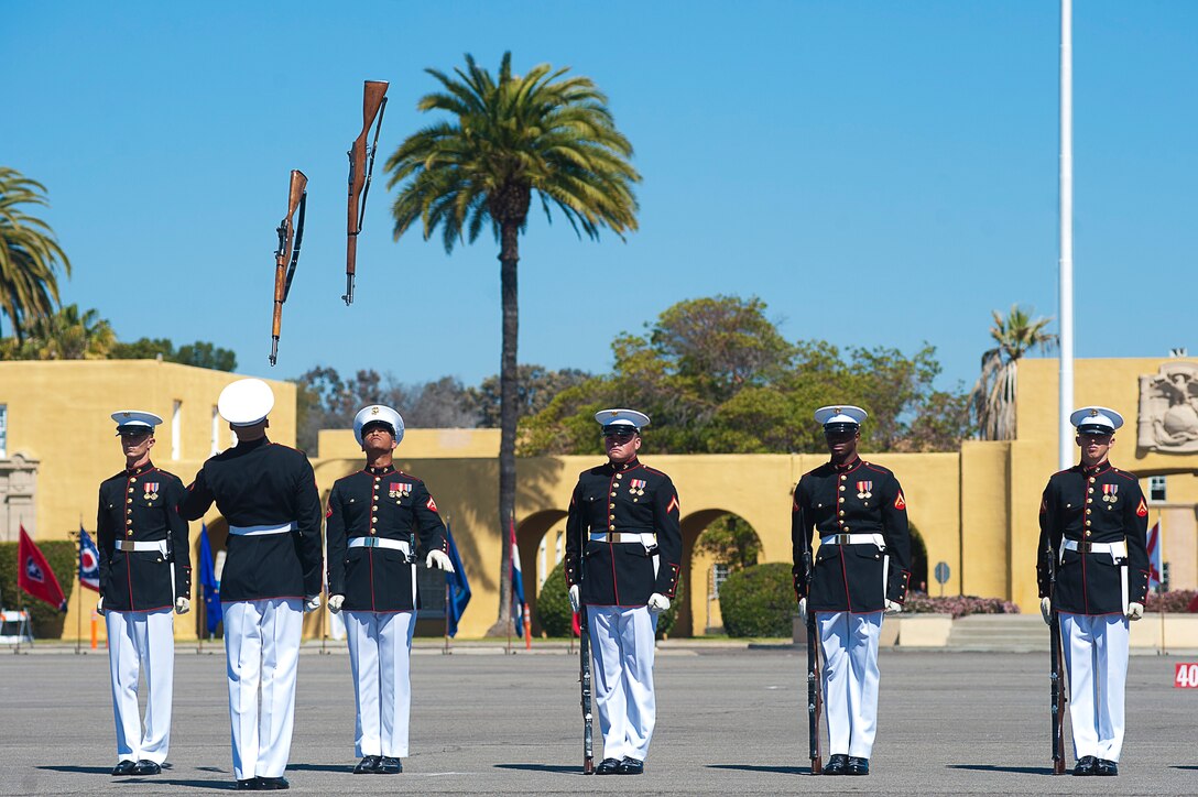 Lance Cpl. Ryan McKinley, left, a Marine Corps Silent Drill Plaoon rifle inspector, and Lance Cpl. Devin Moss, right, a double with the same unit, perform a rifle throw as part of the inspection routine during a Battle Color Detachment ceremony at Marine Corps Recruit Depot, San Diego, Calif., March 10, 2012.