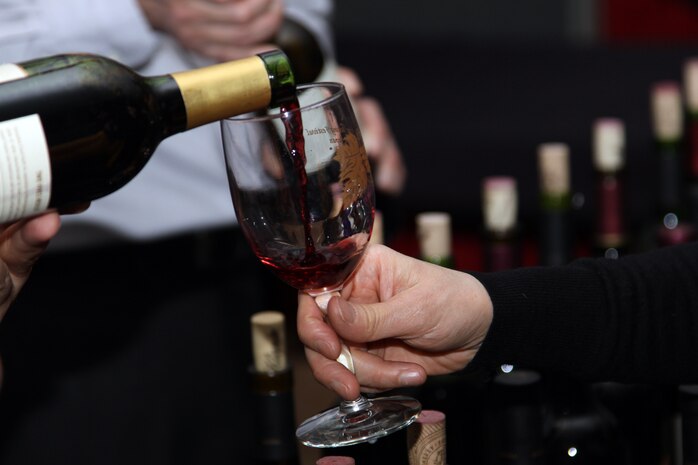 Red wine pours into a patron’s glass during the Marine Corps Community Services 11th annual Wine Festival at the Marine Corps Air Station Iwakuni Club Iwakuni ballroom March 10. The festival featured more than 100 different types of wine from around the world.::r::::n::(U.S. Marine Corps Photo by Lance Cpl. J. Gage Karwick/Released