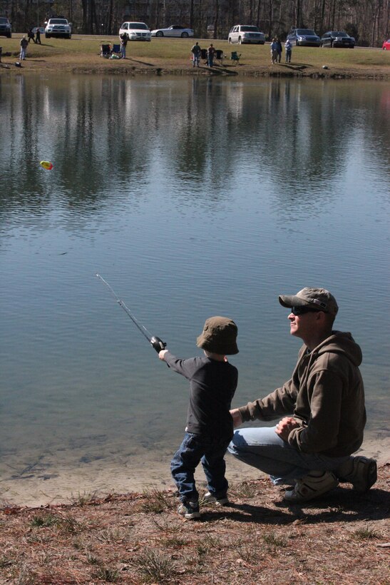 Sgt. Daniel Pluth, a rifleman with 1st Battalion, 6th Marine Regiment, 2nd Marine Division, watches his son cast during the Family Fun Fishing event, hosted by the Outdoor Adventures branch of Marine Corps Community Services at Orde Pond aboard MCB Camp Lejeune, March 10. The pond was stocked with nearly 400 pounds of fish for families to enjoy.