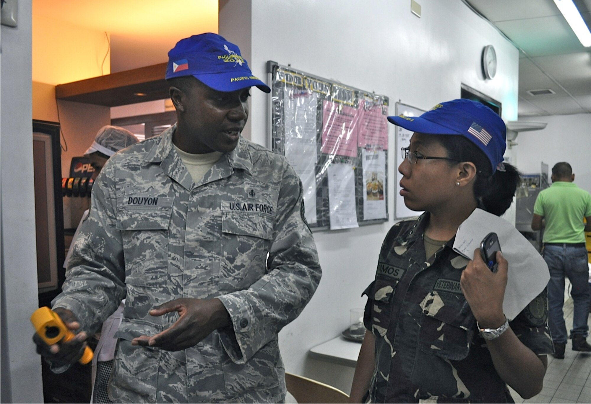 Tech. Sgt. Gregory Douyon, 36th Contingency Response Group non-commissioned officer in charge of public health, Andersen Air Force Base, Guam, and Philippines Veterinary Corps Capt. Mary Grace Ramos, veterinarian officer, discusses food safety inspection at a restaurant March 6, 2012 during a subject-matter expert exchange in Legazpi City, Philippines. The SMEEs were part of Operation Pacific Angel-Philippines, a joint and combined humanitarian operation March 5 through 10. In addition to SMEEs, the operation included medical, dental, optometry and engineering support. (U.S. Air Force photo/Master Sgt. Allison Day)
